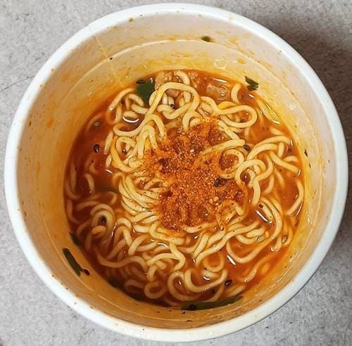 明星 モード学園コラボ 辛DEMO幸 ハニーバター風旨辛チゲラーメン 七味唐辛子投入.jpg